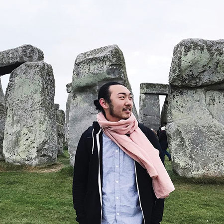 A student standing at the stonehenge site