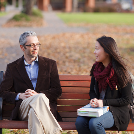 Student and Professor sitting on a bench talking