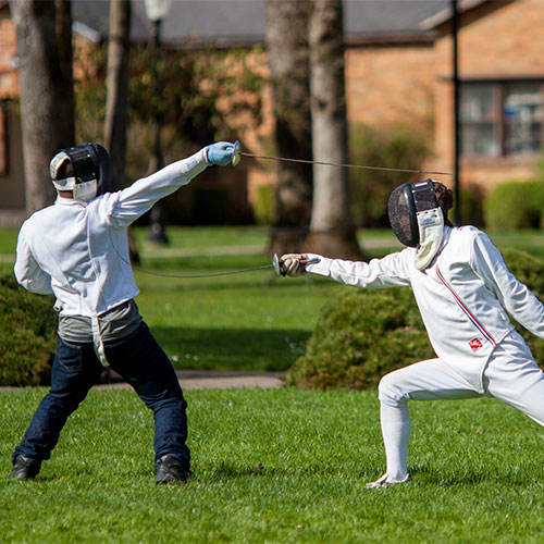 Students in fencing club practicing outdoors