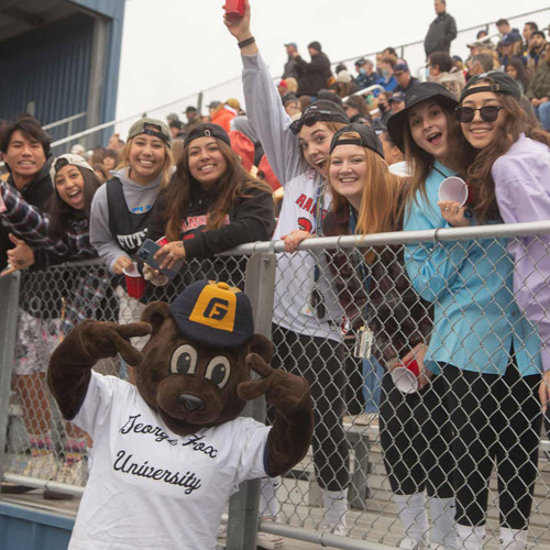 Students pose with mascot Pennington at football game
