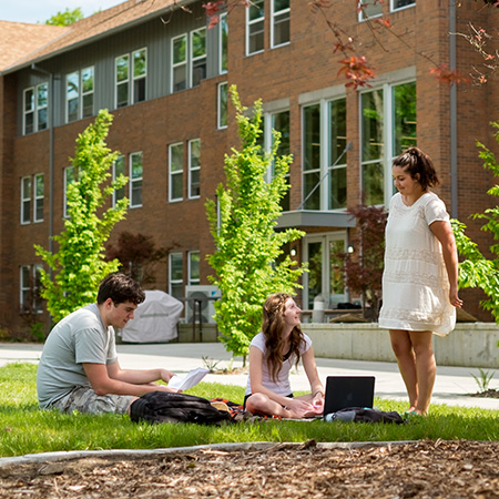 Students sitting outside in their residence hall