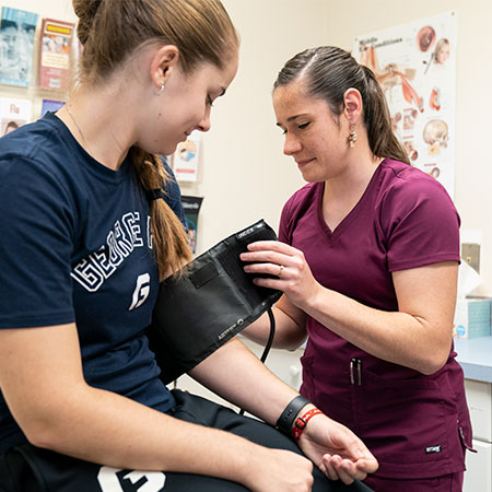A nurse checking the blood pressure of a student