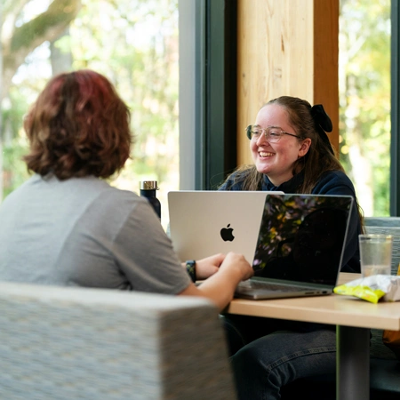 Student smiling and talking with a teacher