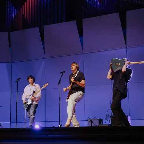 3 Students perform in a cover band on stange