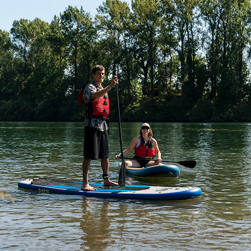 Two students paddle boarding