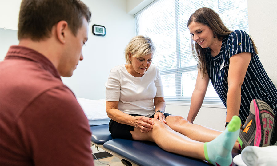 Two students in Physical Therapy program working with a patient