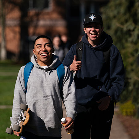 Two undergraduate students walking together with big smiles