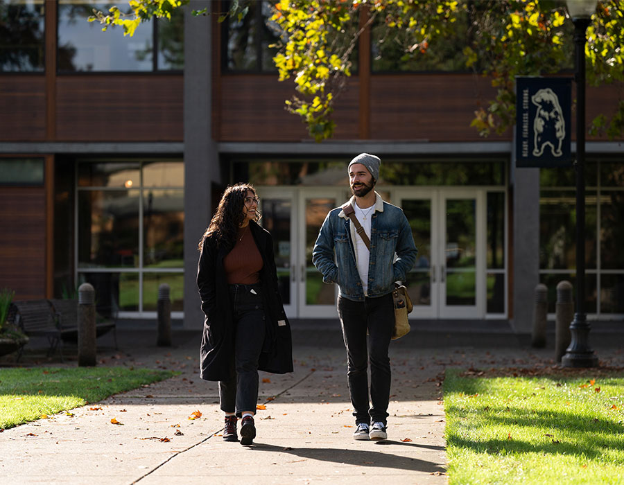 Two graduate students walking on campus