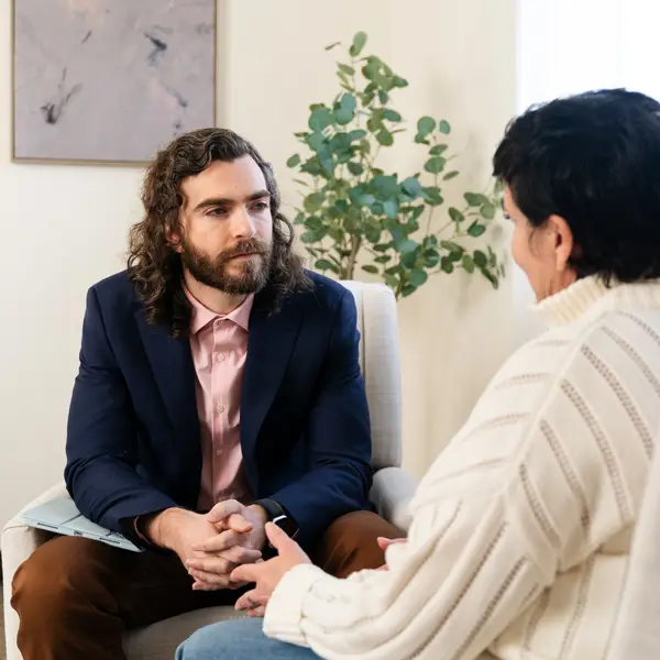PsyD graduate speaks with his client in a brightly lit office