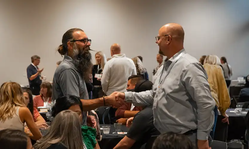 Two seminary students meeting and shaking hands. One has a long beard