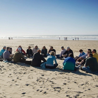 cohort having a discussion on the beach